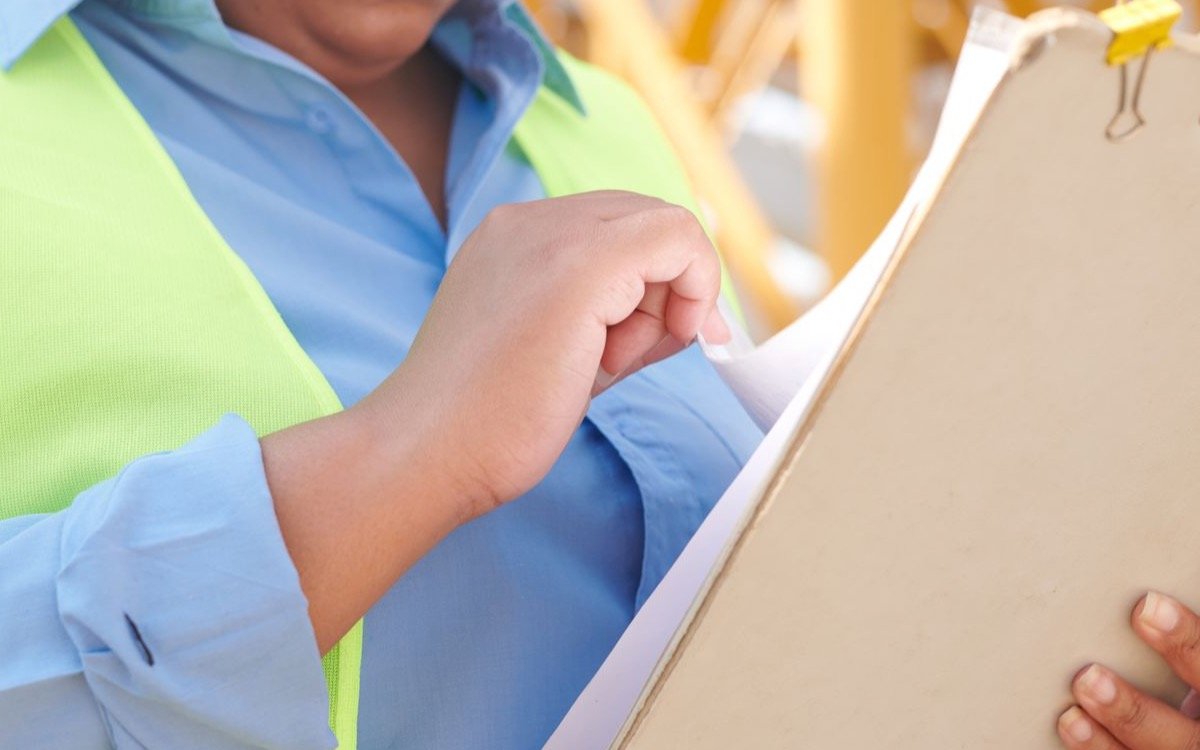 Licencias de construcción — ingeniera revisando documentos en obra